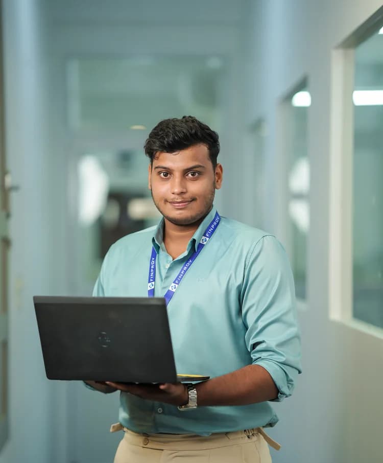 A Finprov student holding his laptop in the centre corridor